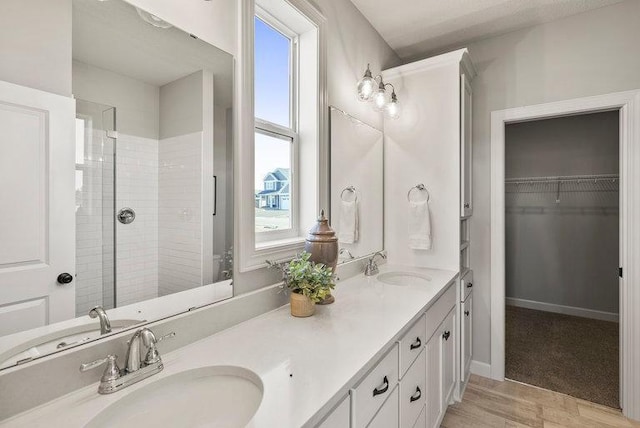 bathroom with vanity and tiled shower