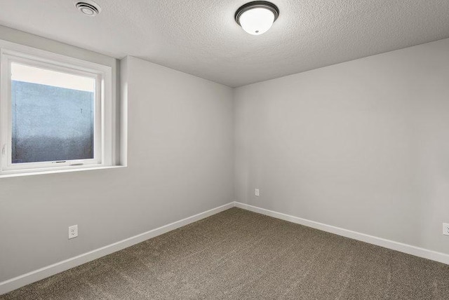 unfurnished room with a textured ceiling and carpet flooring