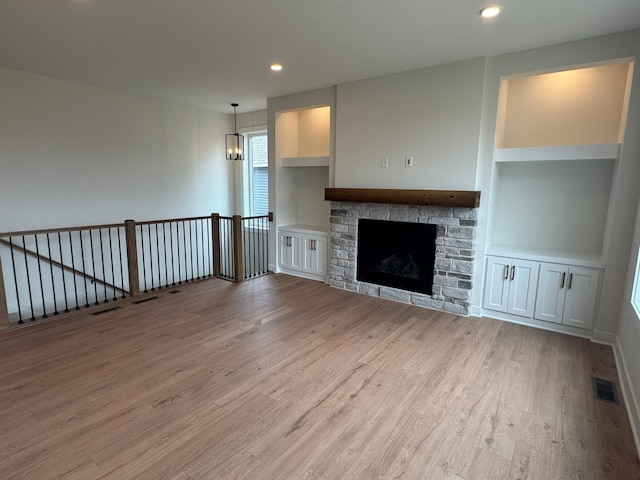14514 Kingsview Ln, Dayton, MN 55327 - unfurnished living room featuring visible vents, recessed lighting, built in shelves, light wood finished floors, and a notable chandelier