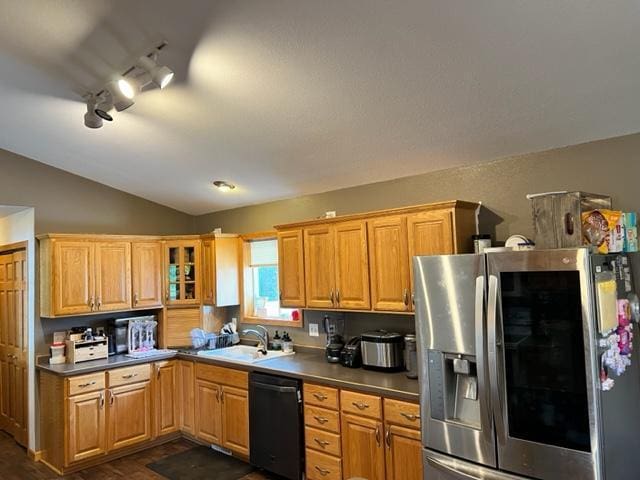 kitchen with stainless steel refrigerator with ice dispenser, vaulted ceiling, black dishwasher, and sink