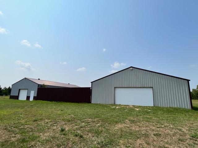 view of outdoor structure featuring a garage and a lawn