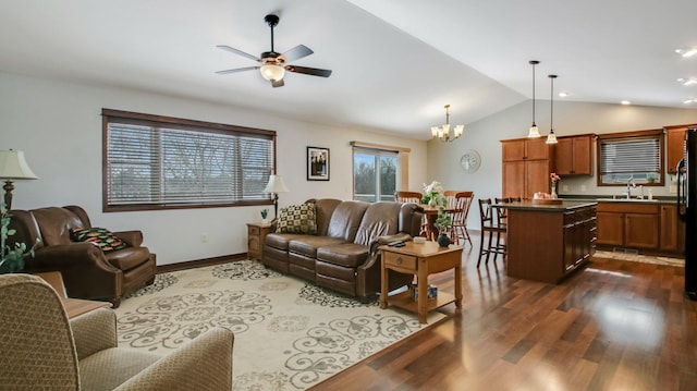 living room featuring ceiling fan with notable chandelier, lofted ceiling, sink, and dark wood-type flooring