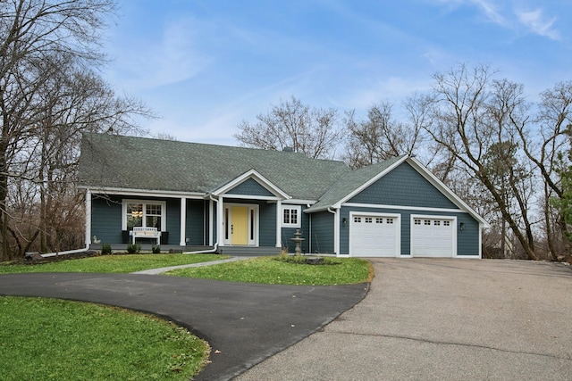 view of front facade featuring a garage, driveway, a shingled roof, and a front lawn