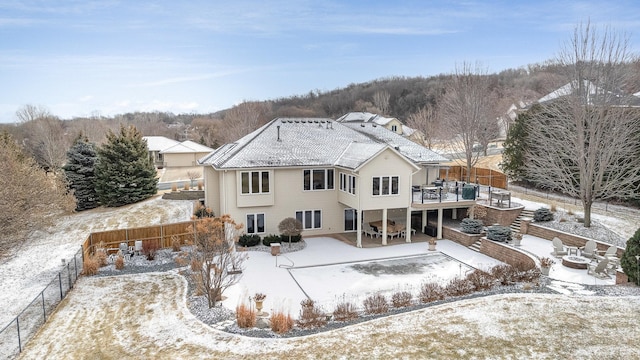 snow covered back of property with a deck