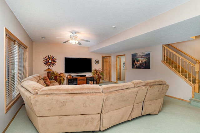 carpeted living room featuring ceiling fan and a textured ceiling