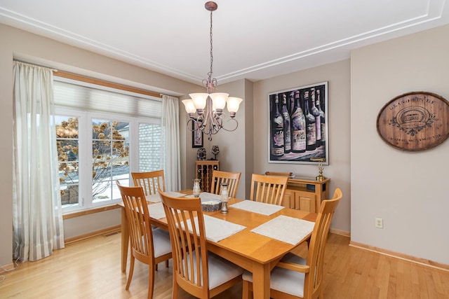 dining area with light hardwood / wood-style flooring and a chandelier