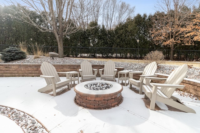 snow covered patio featuring an outdoor fire pit