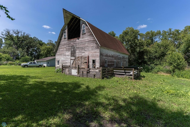 view of side of property featuring an outbuilding and a yard