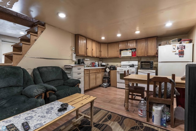 kitchen featuring white appliances and light hardwood / wood-style flooring