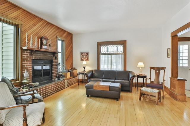 living room with a fireplace and light wood-type flooring