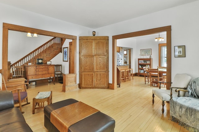 living room with light wood-type flooring and an inviting chandelier