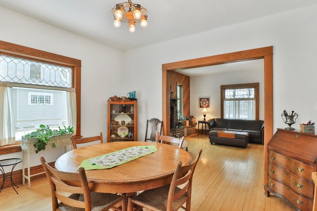 dining area with light hardwood / wood-style floors and a notable chandelier