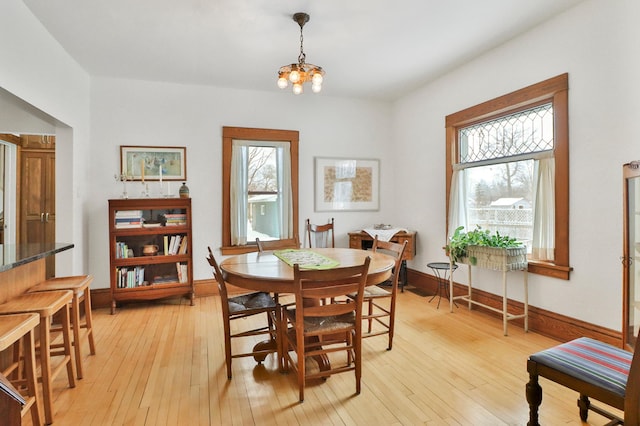 dining area with a chandelier and light hardwood / wood-style flooring