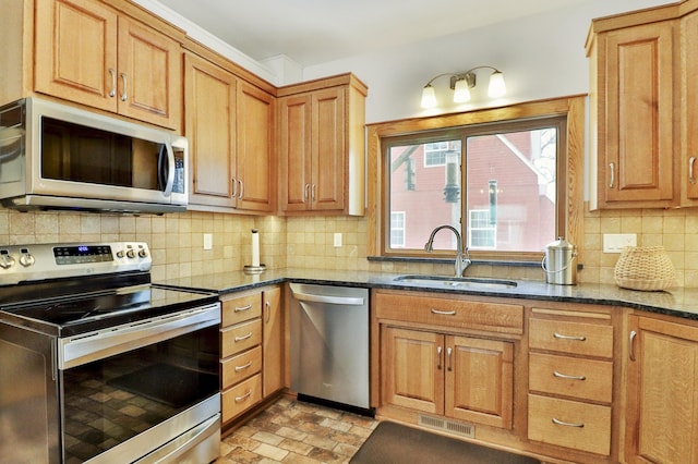 kitchen featuring backsplash, stainless steel appliances, sink, and dark stone counters