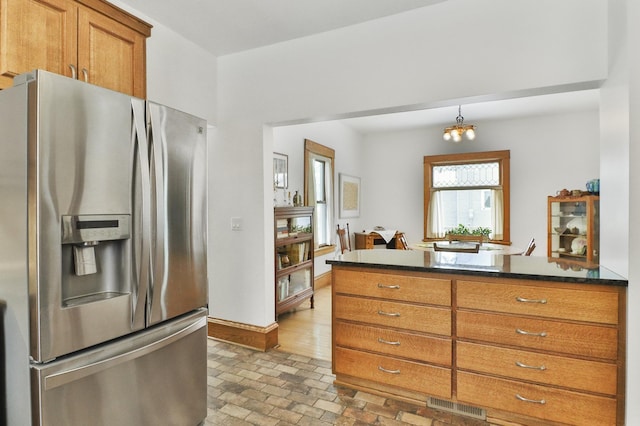 kitchen featuring stainless steel refrigerator with ice dispenser and pendant lighting