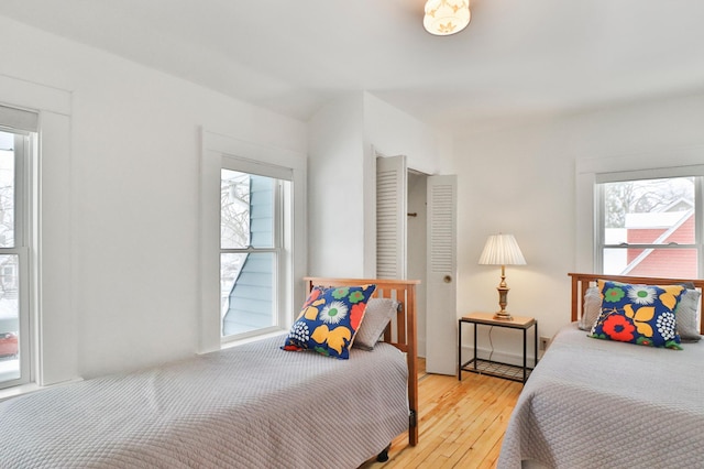 bedroom featuring multiple windows and light hardwood / wood-style flooring