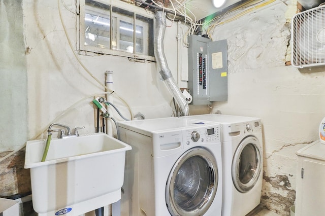 laundry area with electric panel, sink, and washing machine and dryer