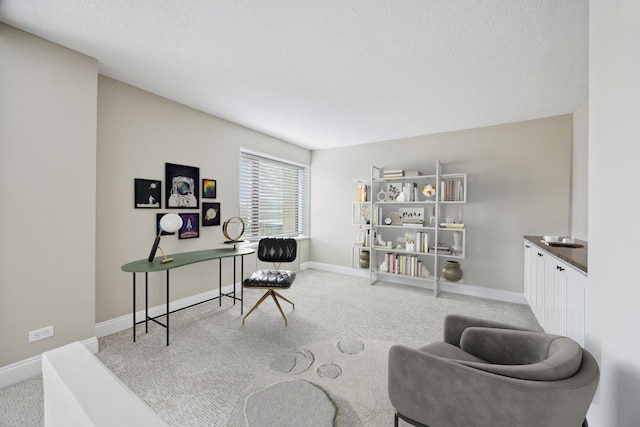 carpeted home office featuring a textured ceiling