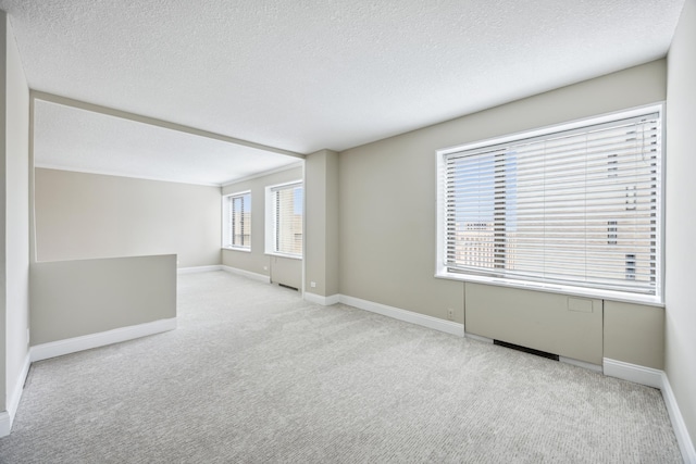 carpeted spare room with a textured ceiling