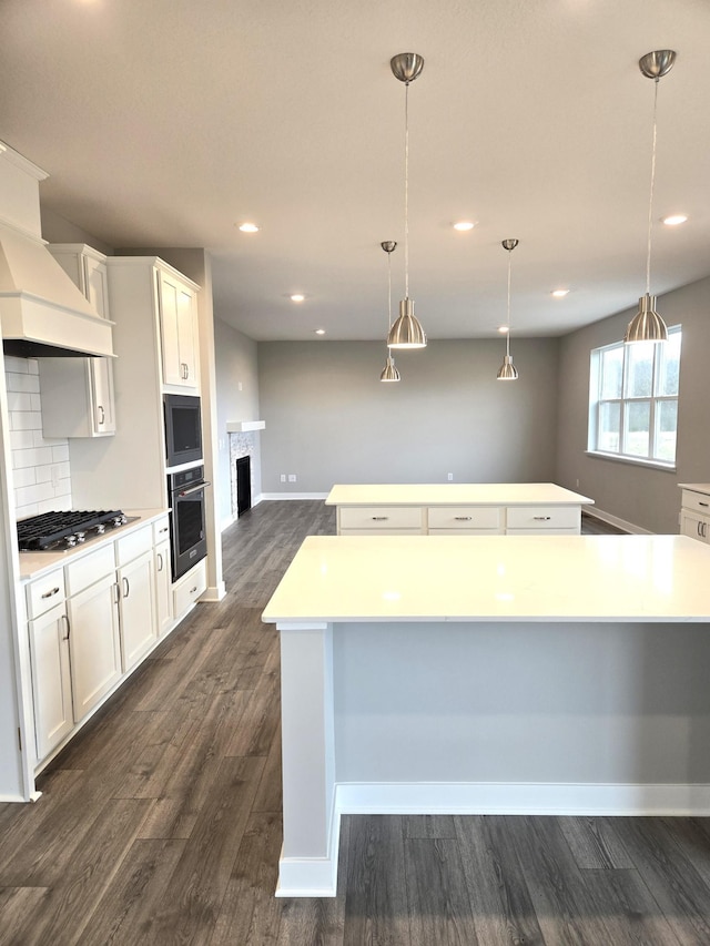 kitchen featuring pendant lighting, a large island, white cabinets, and appliances with stainless steel finishes