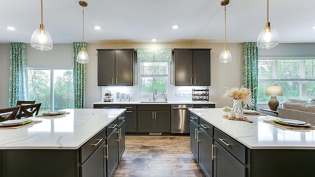 kitchen with pendant lighting, sink, dishwasher, tasteful backsplash, and light stone countertops