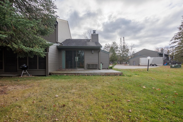 back of house featuring a wooden deck and a yard