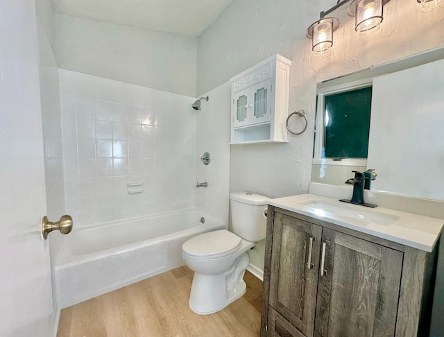 full bathroom with vanity, hardwood / wood-style flooring, tiled shower / bath combo, and toilet