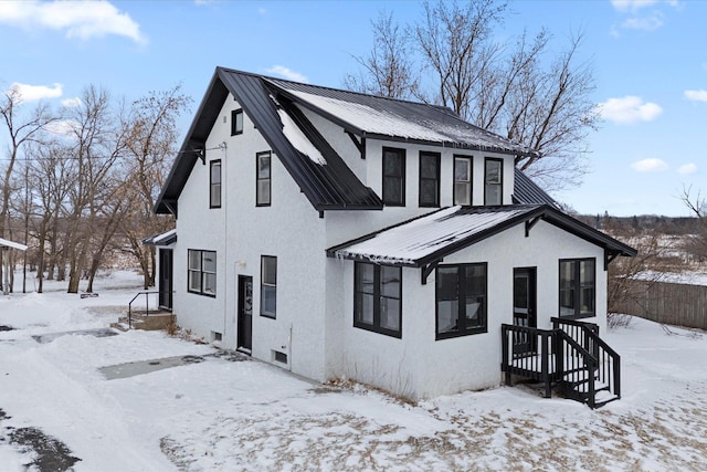 view of front of home featuring stucco siding and metal roof