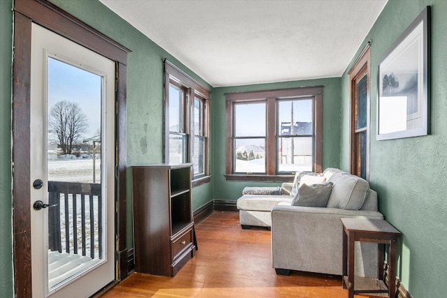 living area featuring baseboards, a textured wall, and wood finished floors