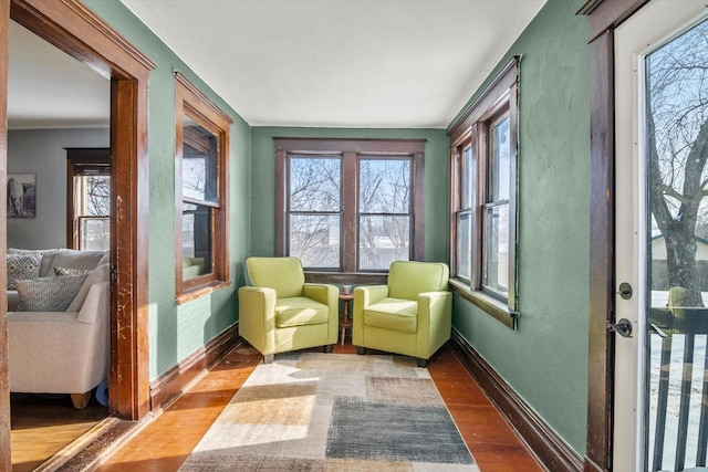 sitting room featuring baseboards, wood finished floors, and plenty of natural light