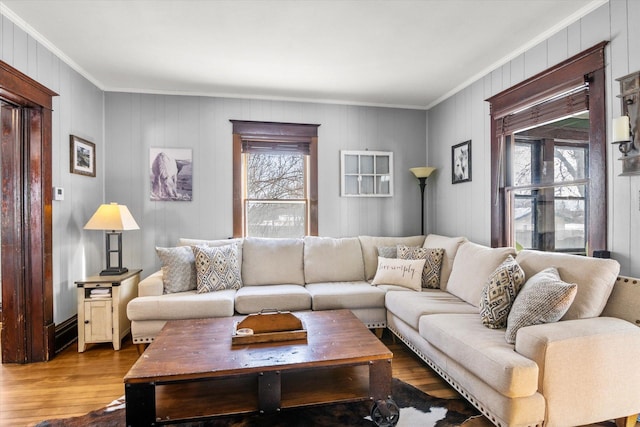 living area with ornamental molding and wood finished floors