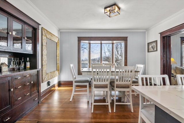 dining space with baseboards, dark wood-type flooring, and ornamental molding