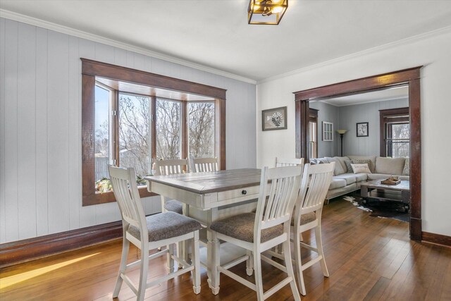 dining area with dark wood finished floors, baseboards, and ornamental molding