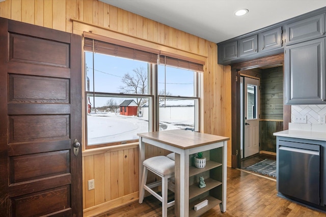 kitchen featuring open shelves, backsplash, wood finished floors, and wood walls