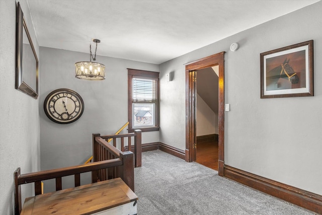 stairway featuring baseboards, an inviting chandelier, and carpet