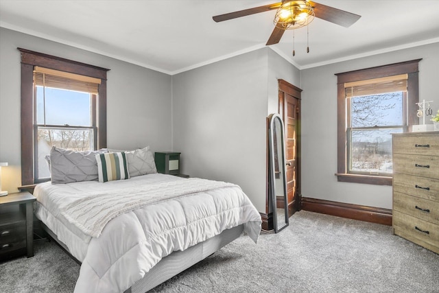 bedroom with crown molding, baseboards, carpet, and multiple windows