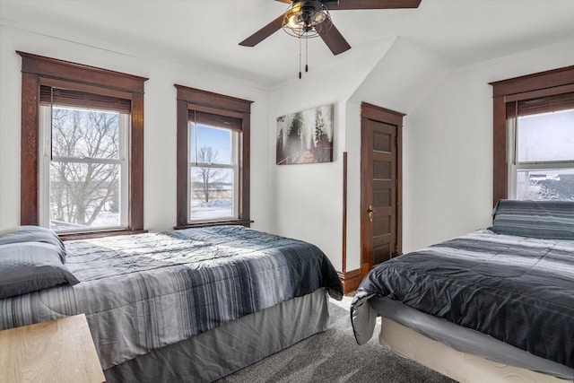 bedroom with carpet floors, ornamental molding, a ceiling fan, and multiple windows