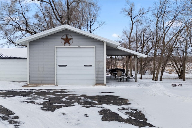 snow covered structure with an outbuilding