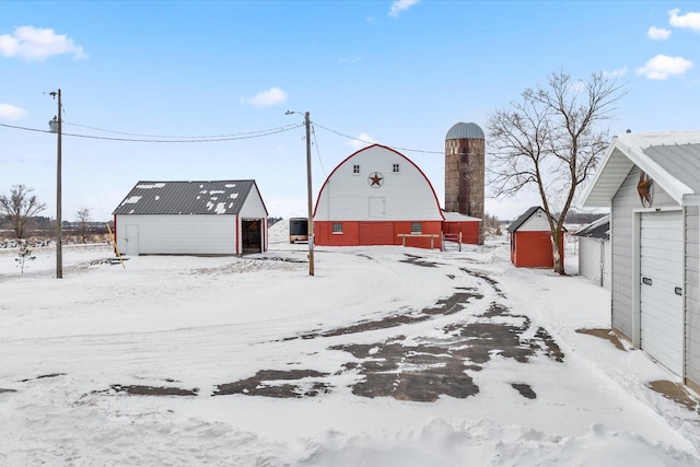 yard layered in snow featuring an outdoor structure and a barn