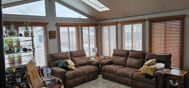 living room featuring a healthy amount of sunlight, lofted ceiling with skylight, and carpet