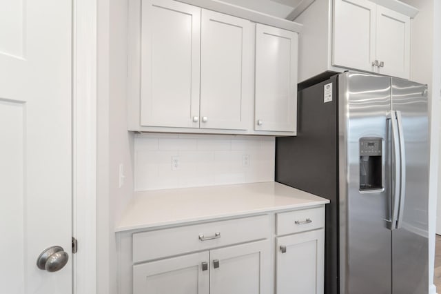 kitchen featuring white cabinetry, stainless steel fridge with ice dispenser, and backsplash