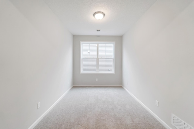 empty room featuring light carpet and a textured ceiling