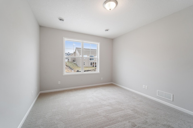 empty room featuring carpet and a textured ceiling