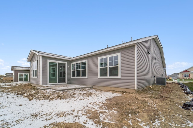 snow covered house with a patio and central air condition unit