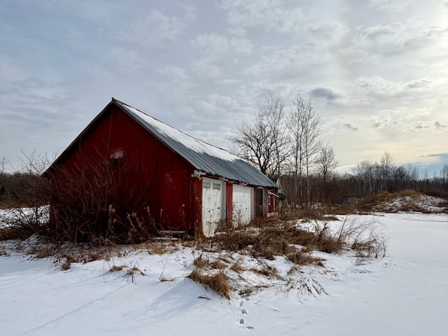 snow covered structure featuring a garage