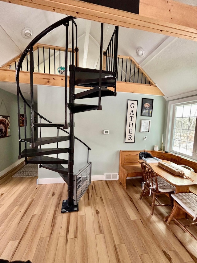 stairway with vaulted ceiling and hardwood / wood-style floors