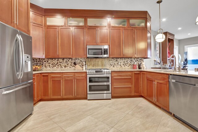 kitchen with stainless steel appliances, sink, backsplash, and decorative light fixtures