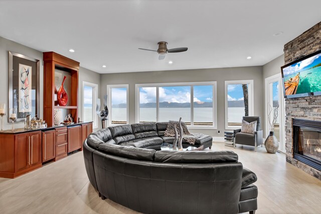 living room featuring ceiling fan and a fireplace