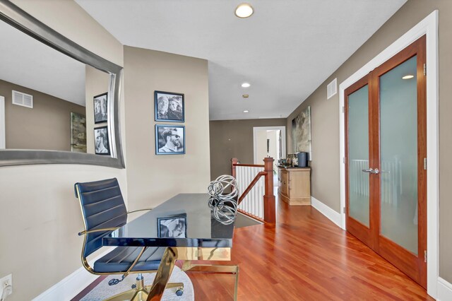 home office with hardwood / wood-style floors and french doors