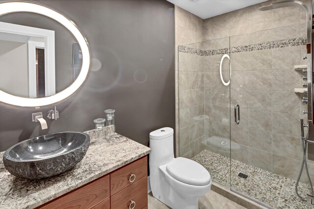 bathroom with an enclosed shower, vanity, and toilet